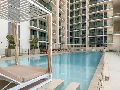 a hotel swimming pool with a chair in front of a building at FIRST CLASS 1BR Luxurious JVC Blissful Escape in Dubai