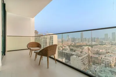 a balcony with two chairs and a view of a city at FIRST CLASS 1BR Luxurious JVC Blissful Escape in Dubai