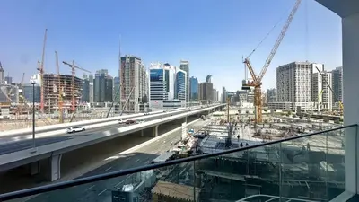 a view of a city with a highway and construction at AWS Holiday Homes - Modernity with a View in Dubai