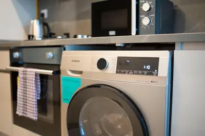 a microwave sitting on top of a washing machine at AWS Holiday Homes - Modernity with a View in Dubai