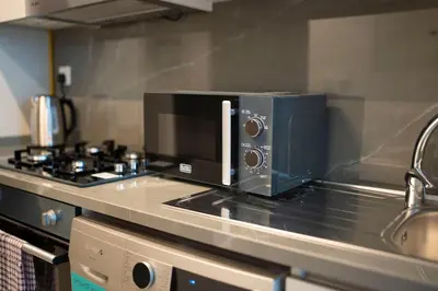 a microwave oven sitting on top of a kitchen counter at AWS Holiday Homes - Modernity with a View in Dubai