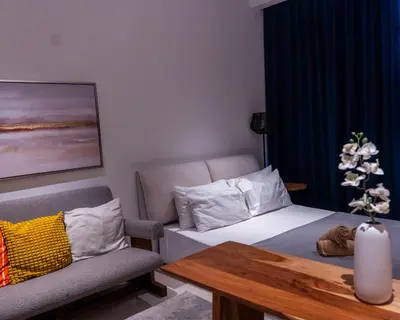 a room with a bed and a chair and a table at Chic Studio with Beach & Rooftop Pool Access in Dubai
