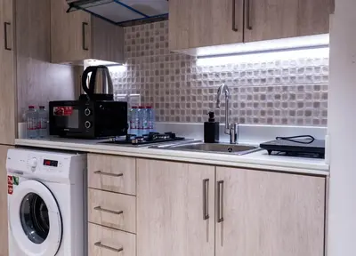 a kitchen with a sink and a washing machine at Chic Studio with Beach & Rooftop Pool Access in Dubai
