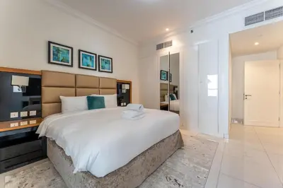 a large bedroom with a large white bed and a room at Elegant Business Bay 2 Bedroom with Sauna, Pool and Jacuzzi in Dubai