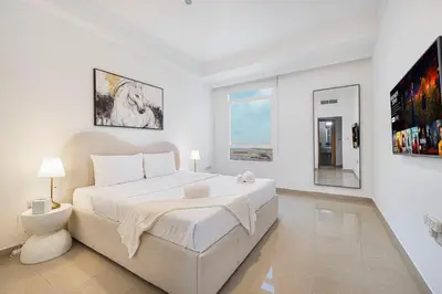 a white bedroom with a large white bed in it at Amazing Palm View - Prime Location - Spacious in Dubai