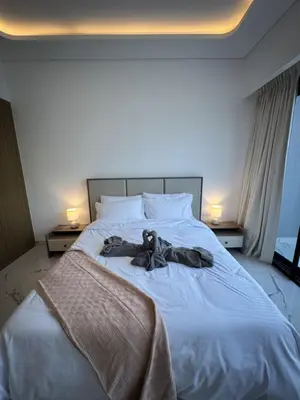a teddy bear laying on top of a bed at DiSalvo Luxury Studio in Azizi riviera 67 in Dubai