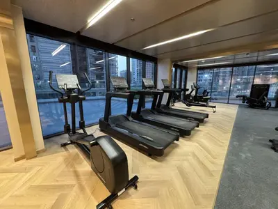 a gym with a row of treadms and exercise equipment at DiSalvo Luxury Studio in Azizi riviera 67 in Dubai