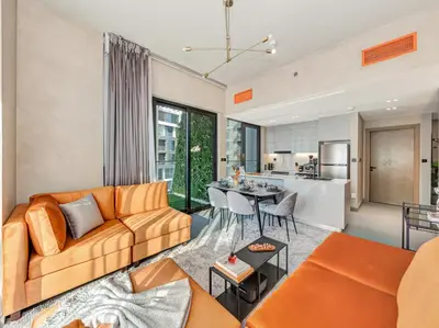 an open living room with a couch and a table at Binghatti Canal 2 Bedroom Suite with Burj Khalifa View, Spacious Balcony, and Infinity Pool in Dubai