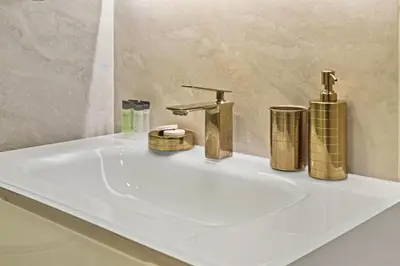 a bathroom sink with gold faucets on it at 3 Bed Spacious JBR Modern Living Holiday Home in Dubai