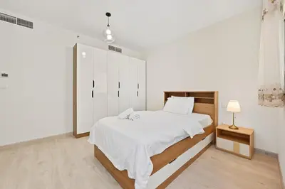 a white bedroom with a bed and a white cabinet at 3 Bed Spacious JBR Modern Living Holiday Home in Dubai