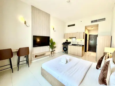 a large living room with a large bed and a television at Signature Horizon Studio with Boulevard Views in Dubai