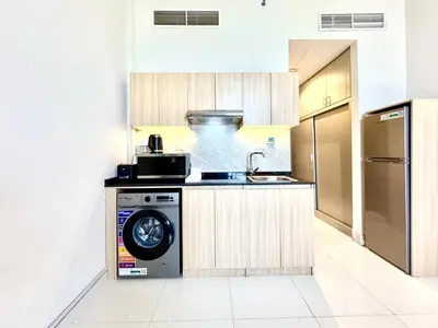 a kitchen with a sink and a washing machine at Signature Horizon Studio with Boulevard Views in Dubai