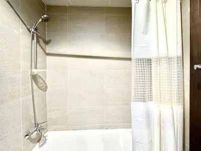a bathroom with a shower with a white shower curtain at Signature Horizon Studio with Boulevard Views in Dubai