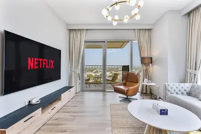a living room with a flat screen tv on a wall at Bright 2BR APT Near The Burj Khalifa and Dubai Mall in Dubai