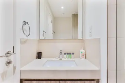 a white bathroom with a sink and a mirror at Bright 2BR APT Near The Burj Khalifa and Dubai Mall in Dubai
