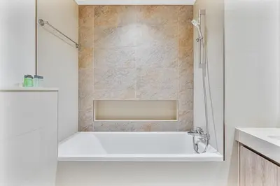 a white bathroom with a tub and a sink at Bright 2BR APT Near The Burj Khalifa and Dubai Mall in Dubai