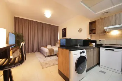 a kitchen with a washing machine in a room at HiGuests - Chic Studio in Downtown Dubai in Dubai