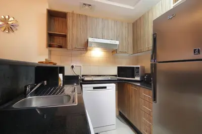 a kitchen with a stainless steel refrigerator and a sink at HiGuests - Chic Studio in Downtown Dubai in Dubai