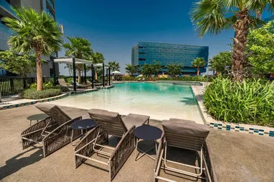 a group of chairs sitting around a swimming pool at Aykon Tower - Studio Apartment - Allsopp & Allsopp in Dubai