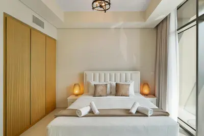 a bedroom with a large white bed with two lamps at Aykon Tower - Studio Apartment - Allsopp & Allsopp in Dubai