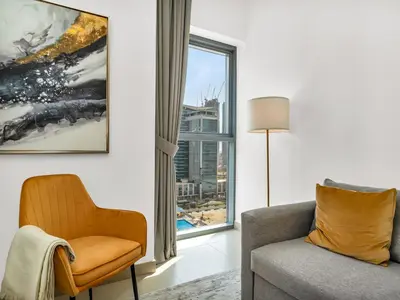 a living room with a chair and a window at Downtown 1BR Pool with Burj Khalifa View Near Dubai Mall in Dubai
