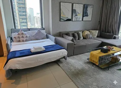 a living room with a bed and a couch at 28th Floor Apartment Next to Burj And Mall Sleeps 7 in Dubai