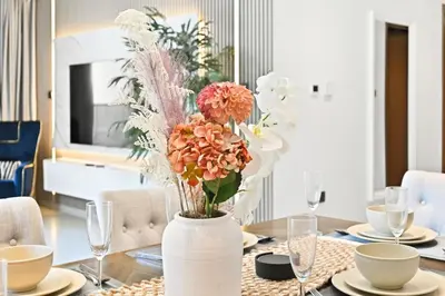 a table with a vase filled with flowers on it at 28th Floor Apartment Next to Burj And Mall Sleeps 7 in Dubai