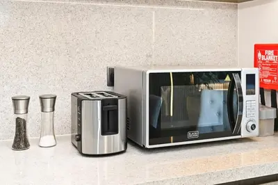 a microwave sitting on a counter next to a coffee maker at 28th Floor Apartment Next to Burj And Mall Sleeps 7 in Dubai