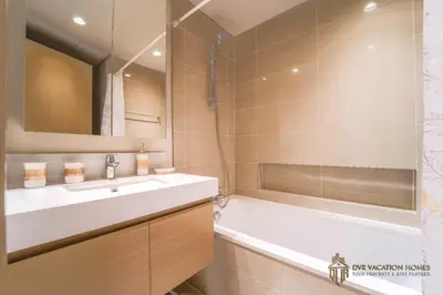 a bathroom with a tub and a sink and a bath tubermottermott at Modern 1BR Apartment in Dubai Creek Harbour by DVR Vacation Homes in Dubai