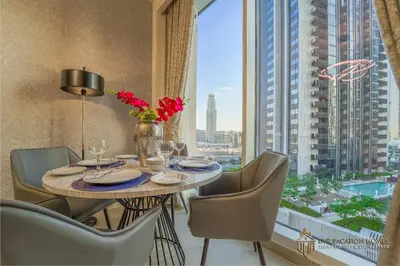 a dining room with a table and chairs and a large window at Modern 1BR Apartment in Dubai Creek Harbour by DVR Vacation Homes in Dubai