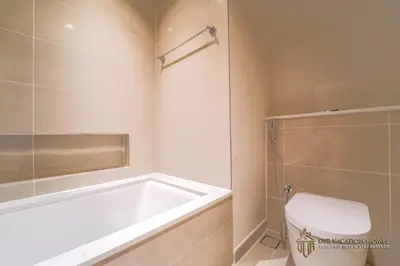 a bathroom with a bath tub and a toilet at Modern 1BR Apartment in Dubai Creek Harbour by DVR Vacation Homes in Dubai