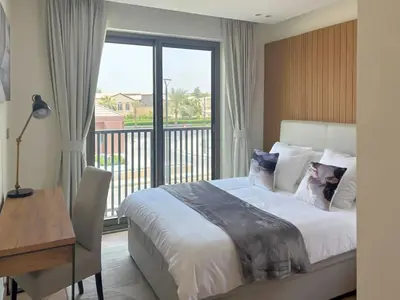 a bedroom with a bed and a desk and a window at Luxury 3BR Villa with Pool View & Modern Comfort in Dubai