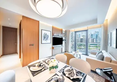 a living room with a dining table and a couch at Luxury 2BR at Address Opera with Burj Khalifa View in Dubai