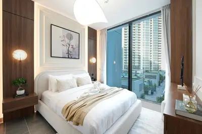 a bedroom with a white bed and a large window at Trophy - Modern 2BR in Crest Tower in Dubai