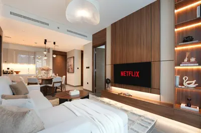 a living room with a white couch and a tv at Trophy - Modern 2BR in Crest Tower in Dubai