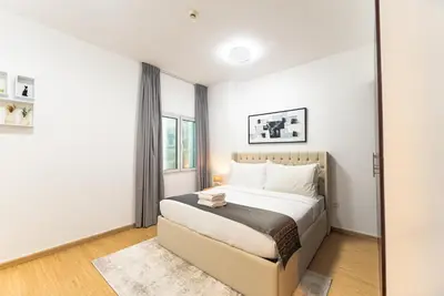 a bedroom with a bed and a window at Escape24 Spacious 1BR with Pool View, JVC in Dubai