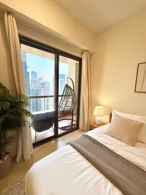 a bedroom with a bed and a balcony with a chair at Tiramisu - Luxurious 2 BR Apartment- JBR Beach in Dubai