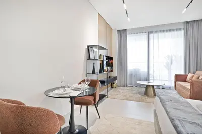 a living room with a table and chairs and a couch at Trillionaire Studio, Canal Views, Private Jacuzzi in Dubai