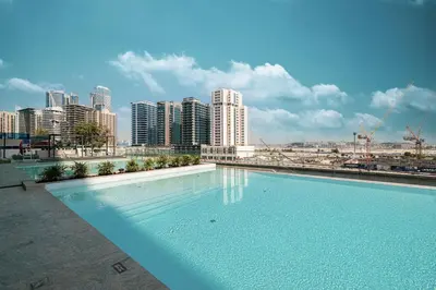 a large swimming pool with a city in the background at Trillionaire Studio, Canal Views, Private Jacuzzi in Dubai