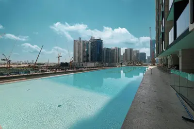 a large swimming pool in a city with tall buildings at Trillionaire Studio, Canal Views, Private Jacuzzi in Dubai