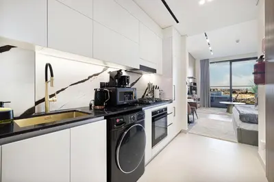 a kitchen with a sink and a dishwasher at Trillionaire Studio, Canal Views, Private Jacuzzi in Dubai
