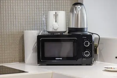 a black microwave sitting on top of a counter at Paramount Luxe Suite, Business Bay in Dubai