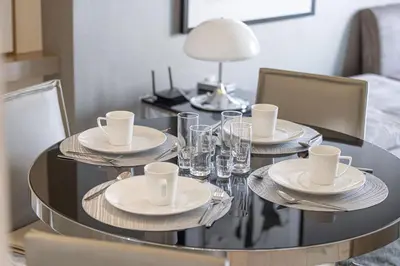 a dining room table with plates and glasses on it at Paramount Luxe Suite, Business Bay in Dubai