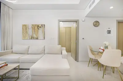 a living room with a white couch and a table at Skyline Retreat, 2BDR Ensuite Comfort, City View in Dubai