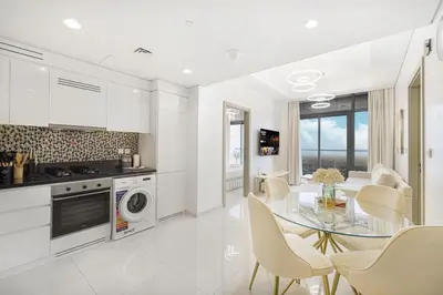 a kitchen and dining room with a table and chairs at Skyline Retreat, 2BDR Ensuite Comfort, City View in Dubai