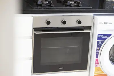 a stove top oven sitting next to a washing machine at Skyline Retreat, 2BDR Ensuite Comfort, City View in Dubai