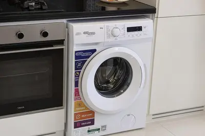 a white washing machine sitting next to a stove at Skyline Retreat, 2BDR Ensuite Comfort, City View in Dubai