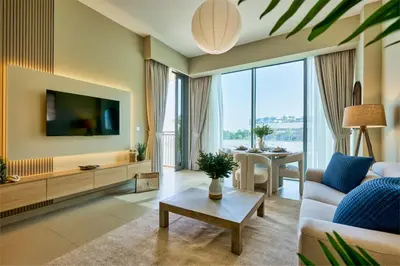 a living room with a tv and a couch and a table at Coastal 1BR with Balcony and Marina Ain Dubai Bluewaters Views in Dubai