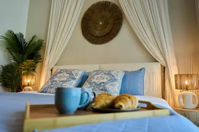 a tray with a plate of bread on a bed at Coastal 1BR with Balcony and Marina Ain Dubai Bluewaters Views in Dubai