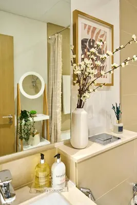 a bathroom with a sink with a vase of flowers at Coastal 1BR with Balcony and Marina Ain Dubai Bluewaters Views in Dubai